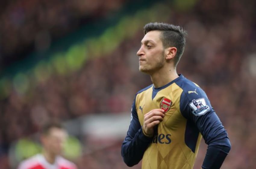 MANCHESTER, ENGLAND - FEBRUARY 28: Mesut Ozil of Arsenal holds his Arsenal badge on his shirt during the Barclays Premier League match between Manchester United and Arsenal at Old Trafford on February 28 in Manchester, England. (Photo by Matthew Ashton - AMA/Getty Images)